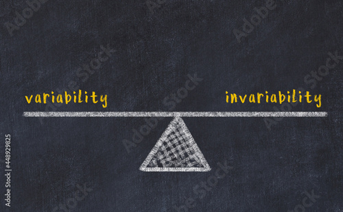 Concept of balance between variability and invariability. Chalk scales and words on it photo