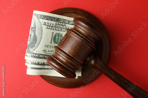 Fotografija Judge gavel with dollars on red background