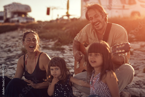 Family on a vacation  singing  playing music on a guitar and enjoying summertime vibes.