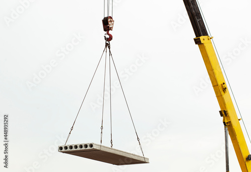 The building crane lifting the concrete plate