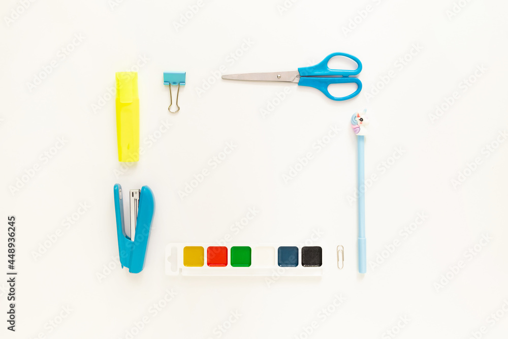 Top view of modern white blue office desktop with school supplies and stationery on table around empty space for text. Back to school concept flat lay with mockup Top view of modern white blue office desktop with school supplies and stationery on table around empty space for text. Back to school concept flat lay with mockup