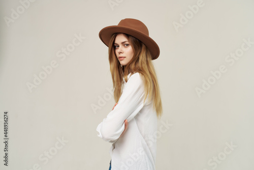 woman wearing hat white shirt studio posing light background