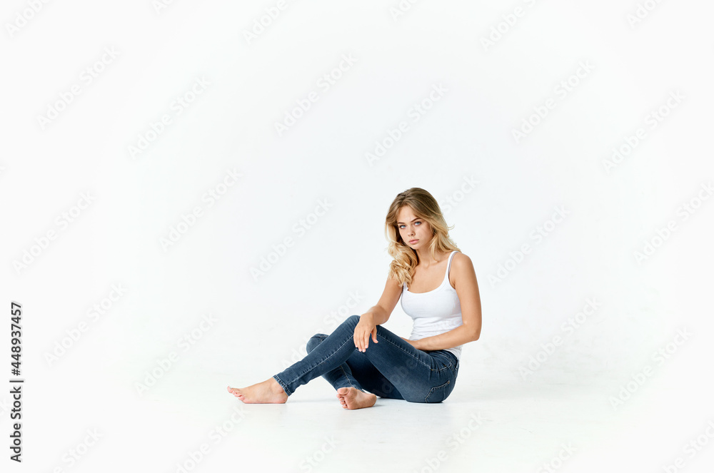 cheap woman in jeans barefoot on the floor fun isolated background cheap woman in jeans barefoot on the floor fun isolated background