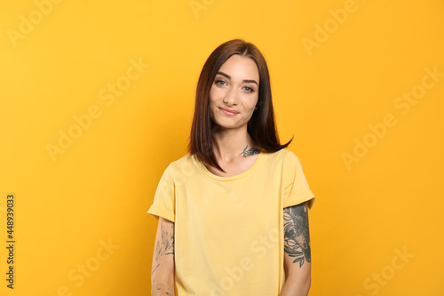 Portrait of pretty young woman with gorgeous chestnut hair on yellow background