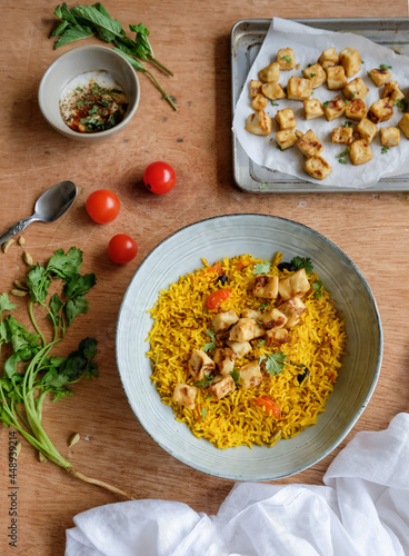 Homemade Middle Eastern cuisine. Turmeric Rice with Crispy Tofu & Spiced Yogurt. Delicious and healthy diet for weight watcher and working professionals photo