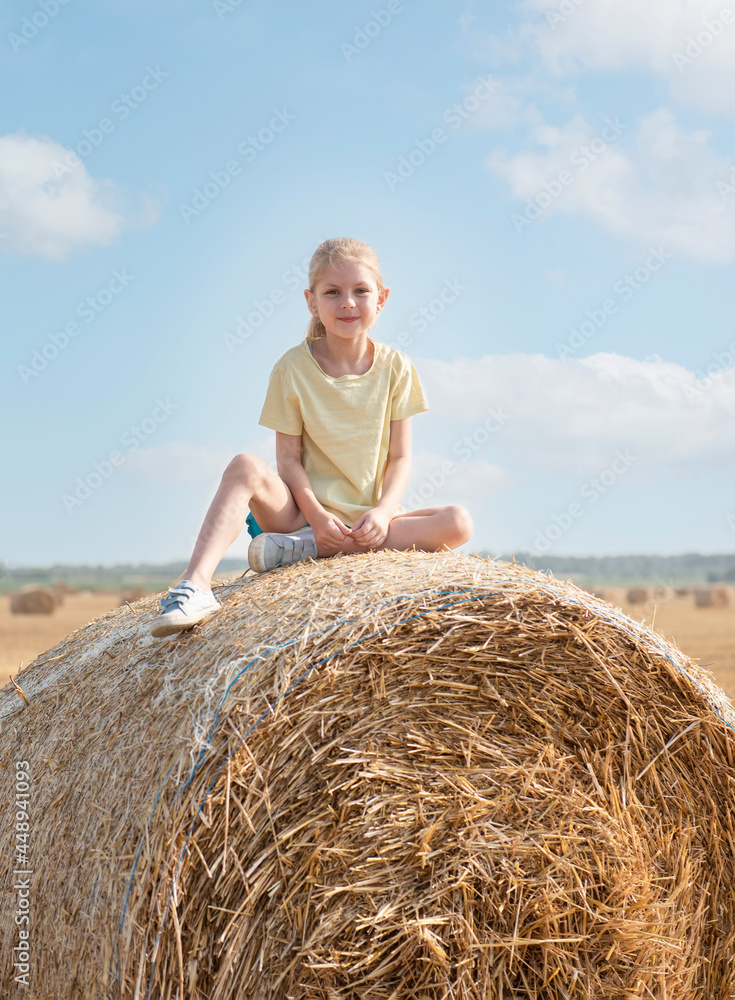 Little girl having fun in a wheat field on a summer day.