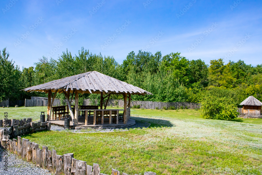 Beautiful wooden gazebo in eco style in a summer park Beautiful wooden gazebo in eco style in a summer park