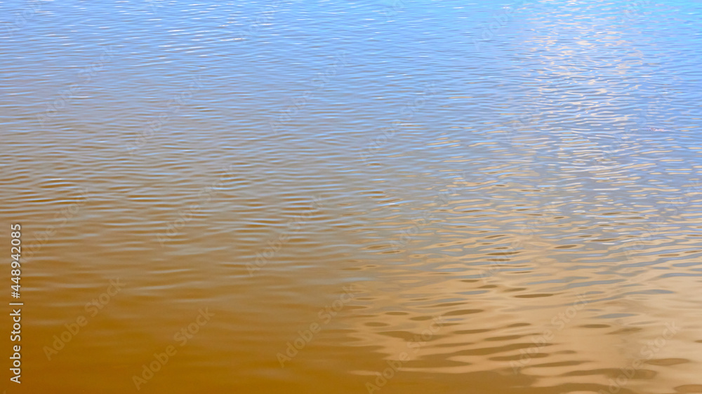 Texture of transparent clear surface of turquoise azure brown amber water with small ripples and sun reflections textured with waves. Texture of transparent clear surface of turquoise azure brown amber water with small ripples and sun reflections textured with waves.