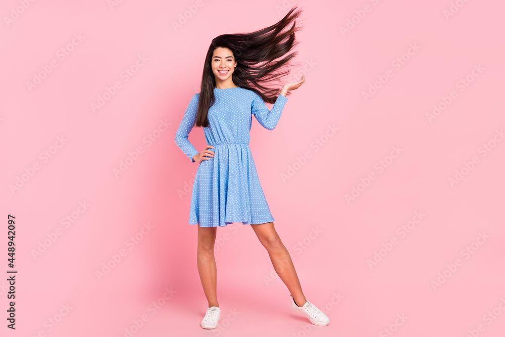 Full length photo of young attractive girl happy positive smile fly air volume hair isolated over pink color background Full length photo of young attractive girl happy positive smile fly air volume hair isolated over pink color background