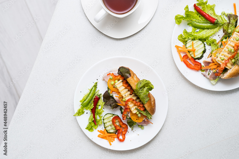 Banh mi sandwiches with various stuffing and cup of tea. Traditional vietnamese breakfast. Trendy still life in light colors, top view, copy space. Banh mi sandwiches with various stuffing and cup of tea. Traditional vietnamese breakfast. Trendy still life in light colors, top view, copy space.