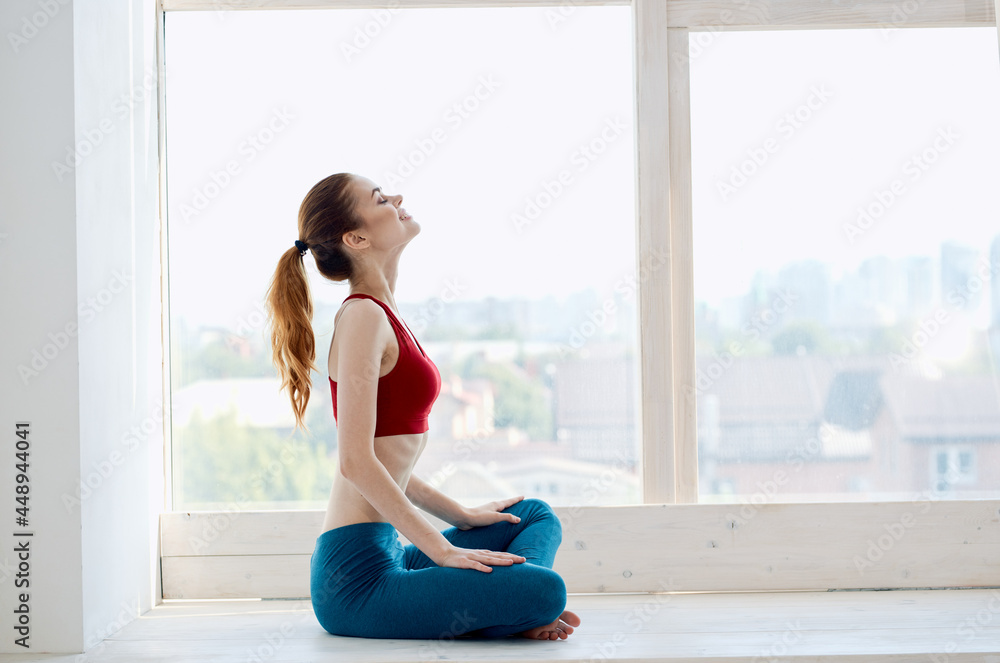 woman doing yoga near window relaxation meditation lifestyle woman doing yoga near window relaxation meditation lifestyle