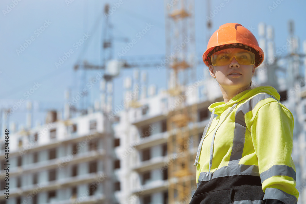 An engineer in a green construction hoodie and helmet manages the construction process by inspecting the construction process An engineer in a green construction hoodie and helmet manages the construction process by inspecting the construction process