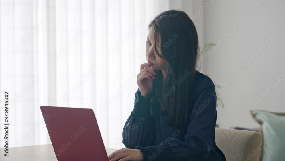 パソコンを見ながら悩む女性　スローモーション