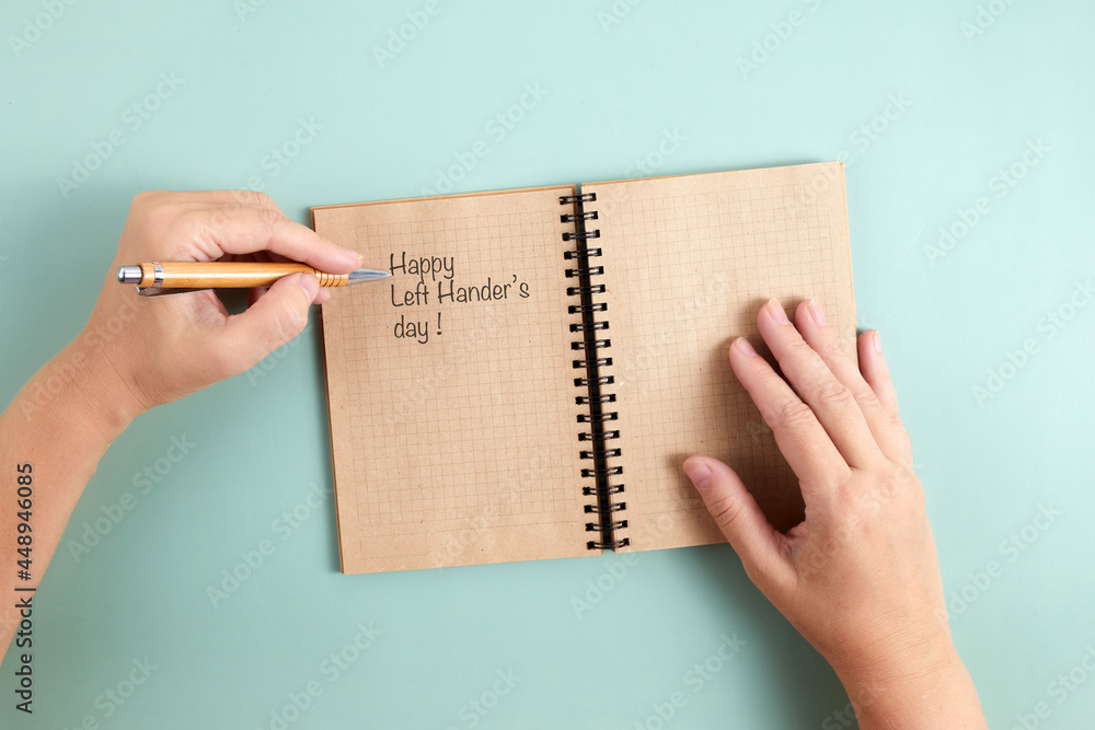 Happy Left Hander's Day. Left hand hold pen and writing text. Happy Left Hander's Day. Left hand hold pen and writing text.