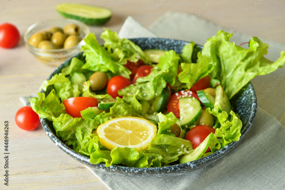 Plate of delicious mixed fresh salad with vegetables on wooden table, closeup Plate of delicious mixed fresh salad with vegetables on wooden table, closeup