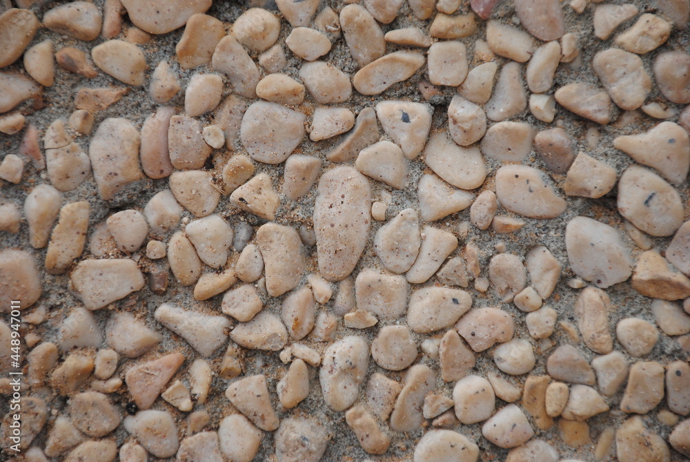 The pebble stone floors and wall, background textures. White granite stone walk way granite stone pavement surface. The pebble stone floors and wall, background textures. White granite stone walk way granite stone pavement surface.