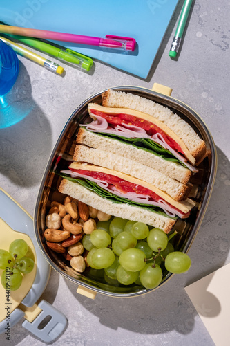 Healthy lunch box with sandwich and fresh fruits and nuts for school lunch photo