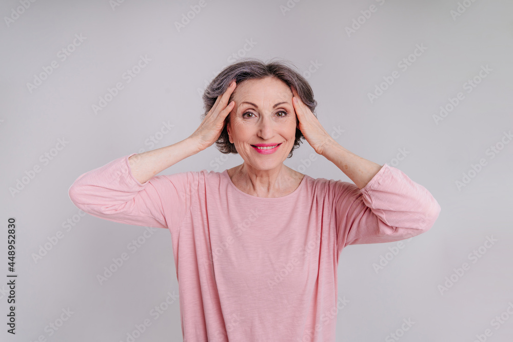 Happy stylish mature woman on light grey background