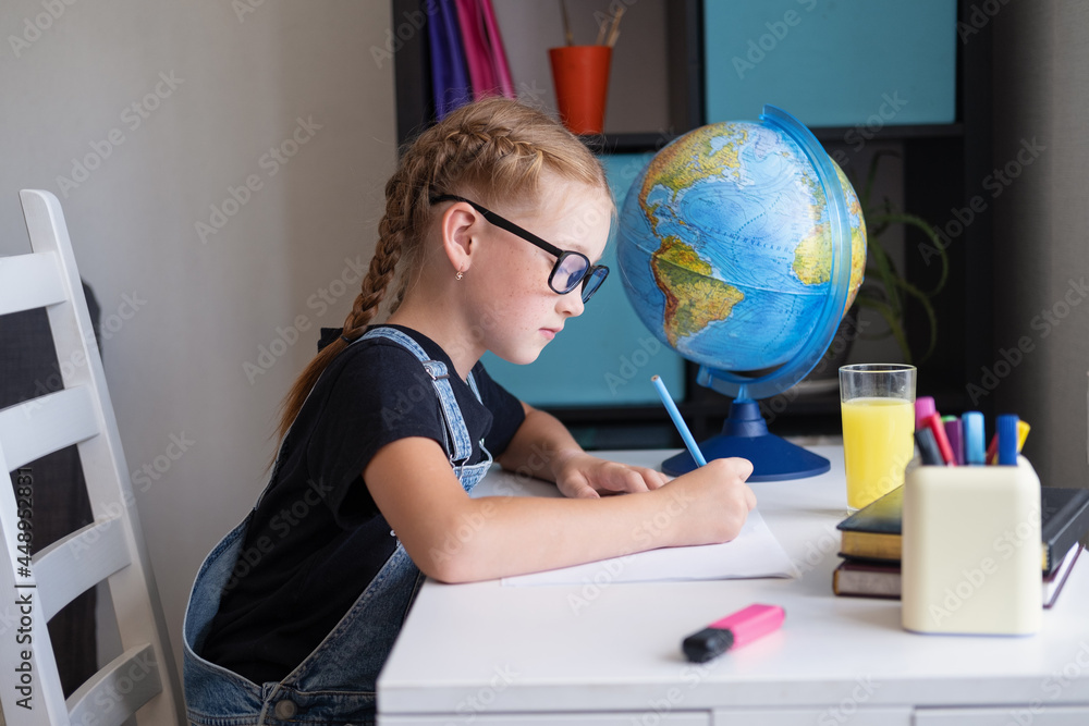 Serious caucasian redhead girl with eyeglasses studying at home, make homework Serious caucasian redhead girl with eyeglasses studying at home, make homework