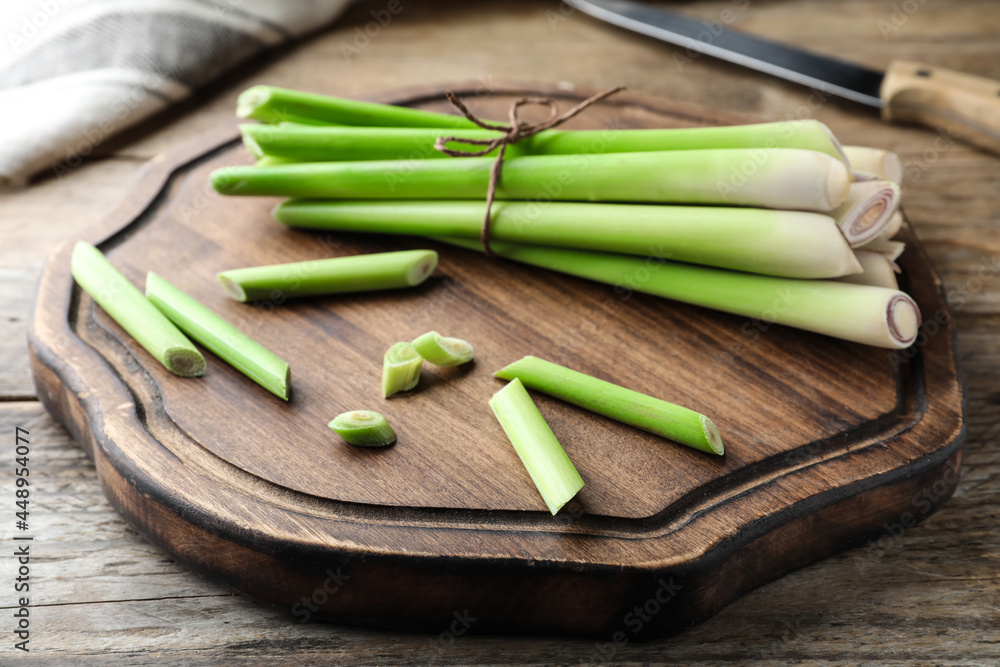Fresh lemongrass, knife and cutting board on wooden table Fresh lemongrass, knife and cutting board on wooden table