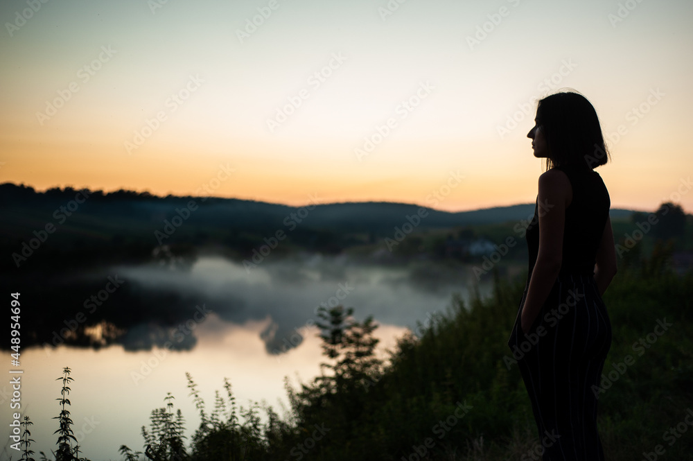 Woman watching the sunset in summer