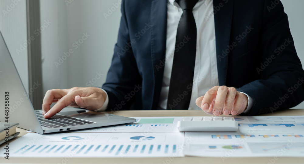 The hand of businessman sit at their desks and calculate financial graphs showing results about their investments, plan a successful business growth process The hand of businessman sit at their desks and calculate financial graphs showing results about their investments, plan a successful business growth process