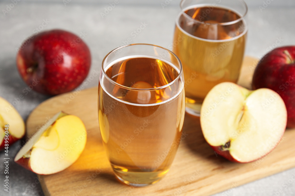 Delicious cider and ripe red apples on grey table Delicious cider and ripe red apples on grey table