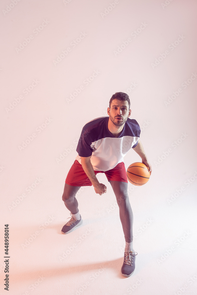Young european sportsman play basketball in studio Young european sportsman play basketball in studio