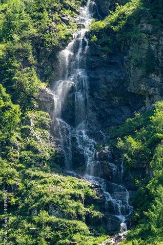 Beautiful high waterfall in the mountains in summertime at a sunny day