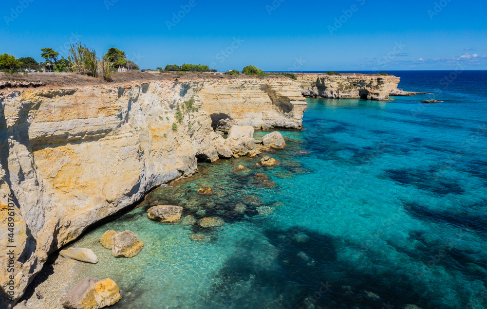 Torre Sant Andrea near Torre dell'Orso, Salento sea coast, Apulia, Italy. Beautiful rocky beach with cliffs in Puglia. Blue turquoise saturated clear water. Bright Summer day. No people.