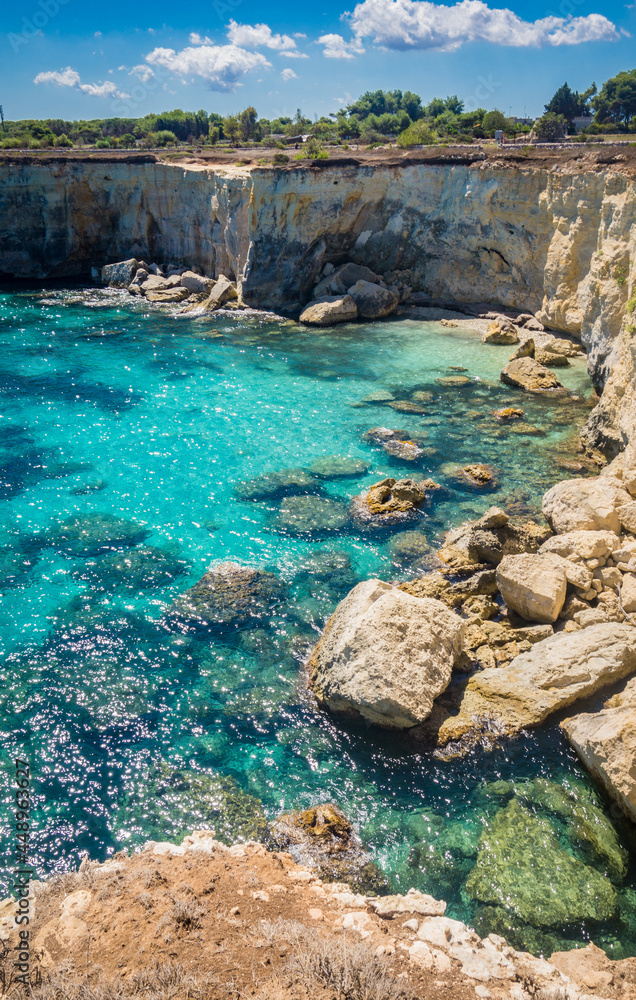 Torre Sant Andrea near Torre dell'Orso, Salento sea coast, Apulia, Italy. Beautiful rocky Seascape with cliffs in Puglia. Blue turquoise saturated clear water. Bright Summer day. No people.