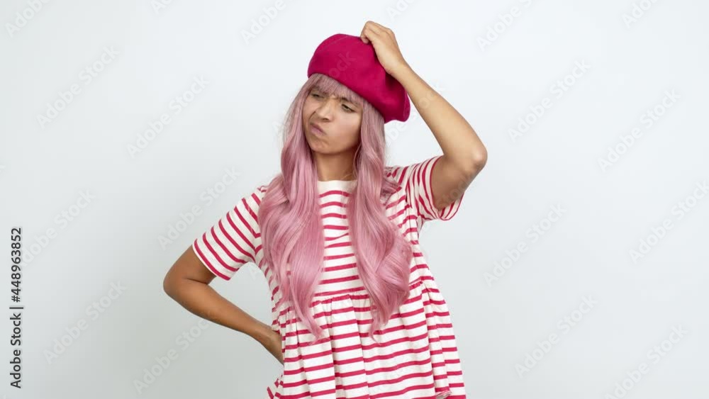 Young woman with pink hair having doubts while scratching head over isolated background Young woman with pink hair having doubts while scratching head over isolated background