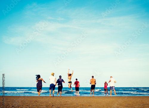 Diverse group of friends running to the beach