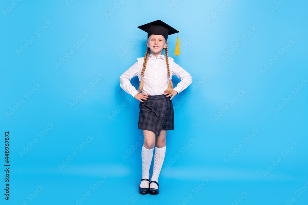 Full length body size photo smiling small girl wearing hat isolated pastel blue color background Full length body size photo smiling small girl wearing hat isolated pastel blue color background