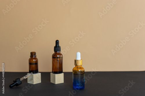Natural essential oil or serum dropper bottles, natural facial brush lie nearby. Beauty and wellness concept. Unbranded products