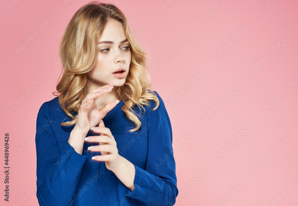 cheerful pretty woman in a blue dress on a pink background cheerful pretty woman in a blue dress on a pink background