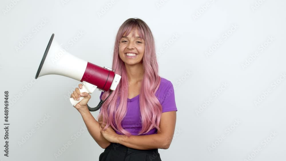 Young woman with pink hair happy and holding a megaphone over isolated background Young woman with pink hair happy and holding a megaphone over isolated background