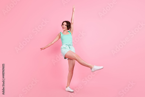 Full body photo of impressed short hairdo young lady dance wear teal top shorts isolated on pink color background