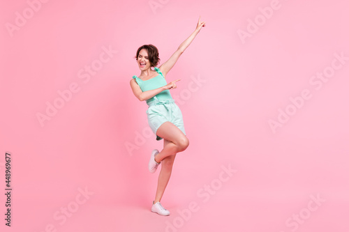 Photo of exited pretty young lady wear teal singlet dancing smiling isolated pink color background