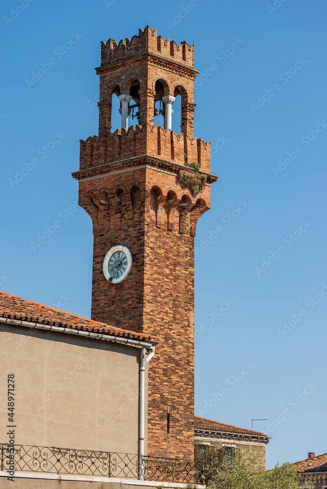 Fototapeta premium Close-up of the ancient Civic Tower or Clock Tower in Murano island in medieval style. Campo Santo Stefano (Saint Stephen square), Venice, UNESCO world heritage site, Veneto, Italy, Europe.