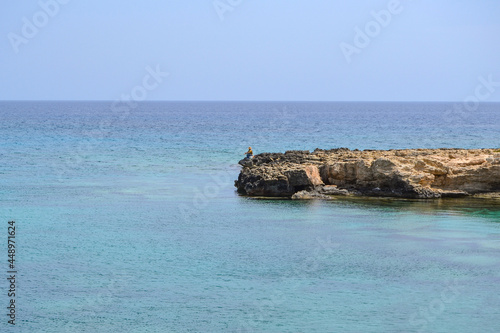 Sea shore. Rocky shore. Rest at the sea. Vacation. Beach. Cyprus. Fishing on the seashore.
