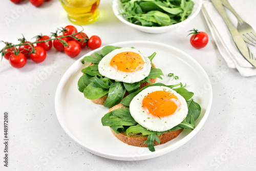 Fried eggs and greens on bread.