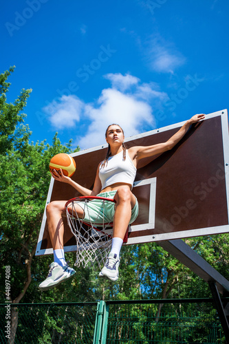 Young beautiful girl posing on the basketball court