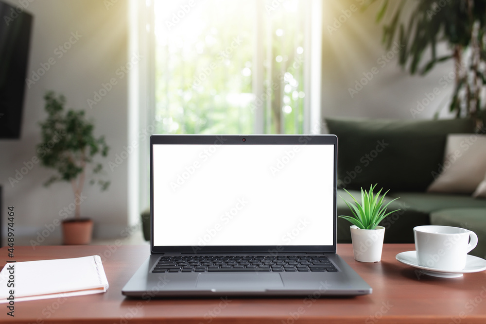Empty laptop screen mock up on table with cup of coffee, note pad and flowerpot Empty laptop screen mock up on table with cup of coffee, note pad and flowerpot