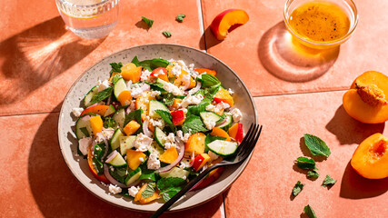 Summer peach and cheese salad on tile table, top view