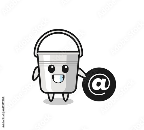 Cartoon Illustration of metal bucket standing beside the At symbol