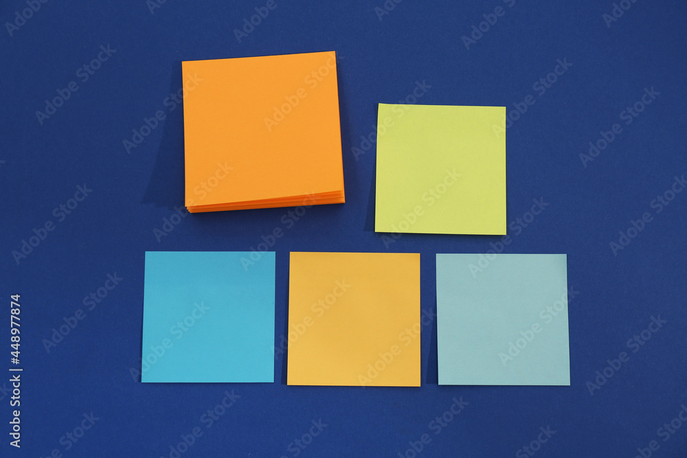 Colorful sticky notes on blue background, flat lay Colorful sticky notes on blue background, flat lay