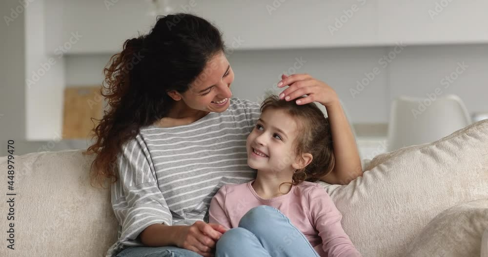 Affectionate caring young mother cuddling happy preteen child daughter, showing tender feelings to cute adopted child. Smiling relaxed two female generations family enjoying sweet weekend pastime. Affectionate caring young mother cuddling happy preteen child daughter, showing tender feelings to cute adopted child. Smiling relaxed two female generations family enjoying sweet weekend pastime.