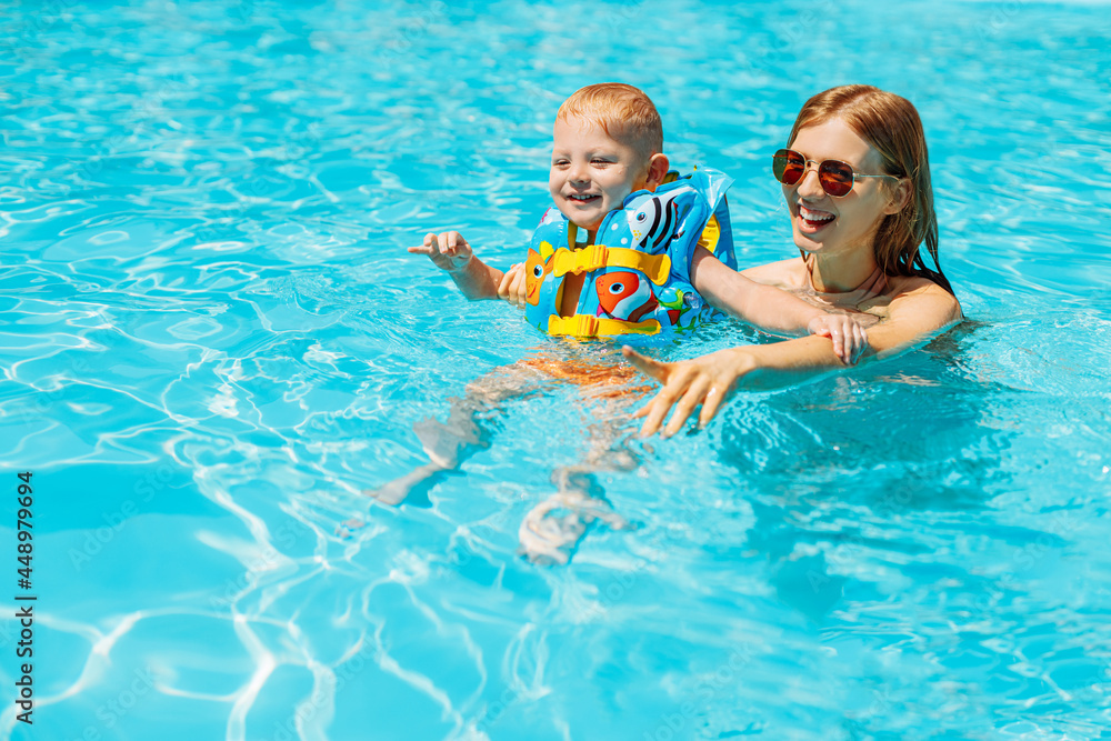 mom and little baby swim in the pool, Happy baby learn to swim, dive underwater with fun in the