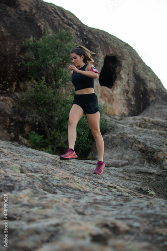Caucasian young woman running in the top of the mountain. © Aleix